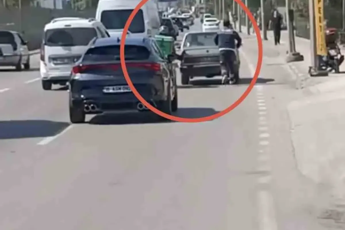 Bursa’da motokuryeden arızalanan otomobili itmek için ilginç yöntem
