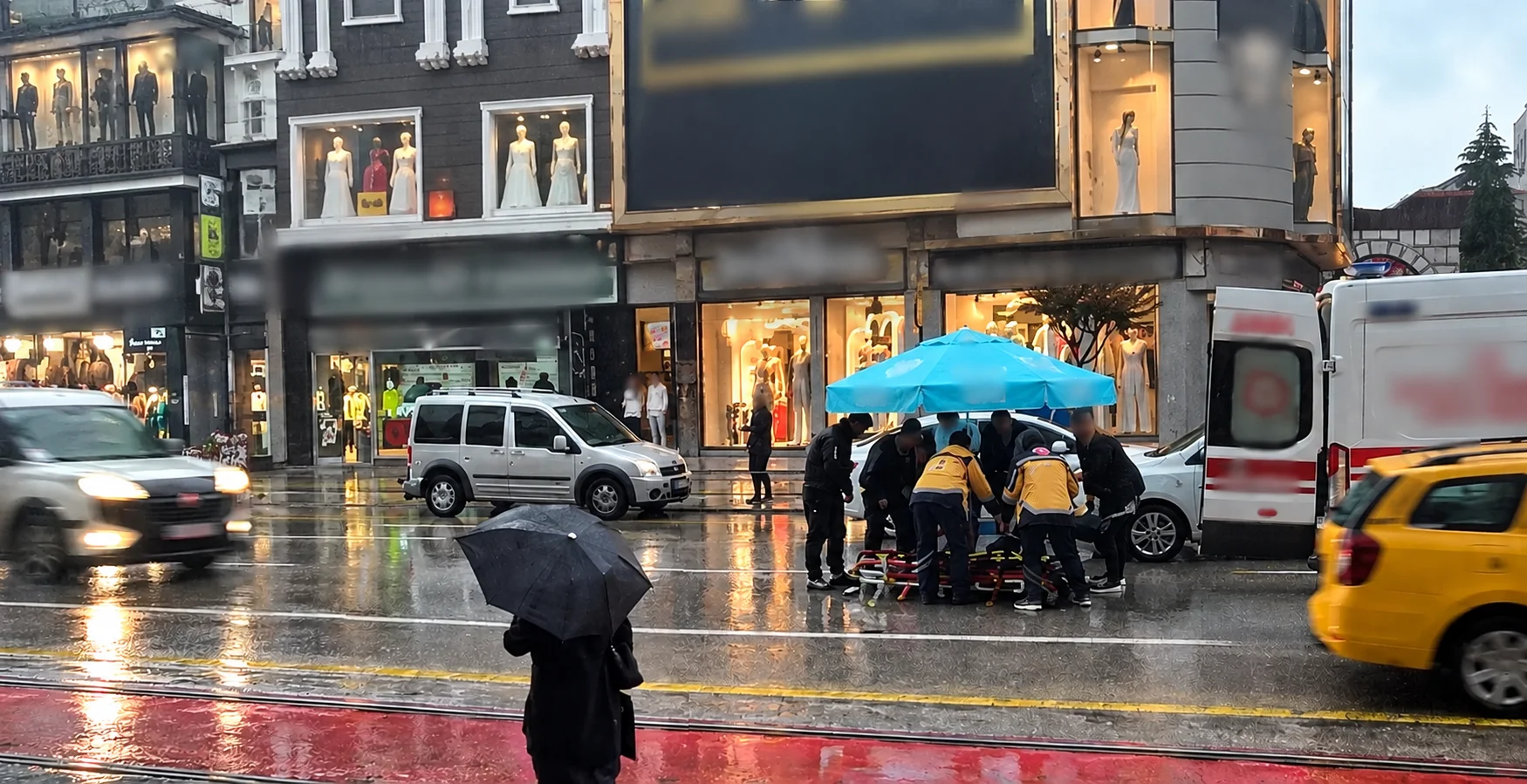 Otomobilin çarptığı yaya yağmur altında kaldı! Şemsiye tuttular